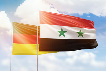 Sunny blue sky and flags of syria and germany