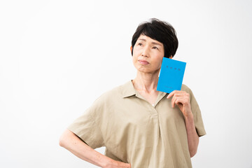 年金手帳を持ちながら不安な表情をするミドル女性