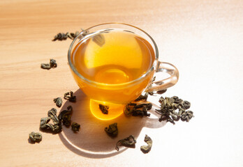 Cup of green tea with dry tea leaves on the table, antioxidant hot drink