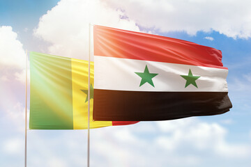 Sunny blue sky and flags of syria and senegal