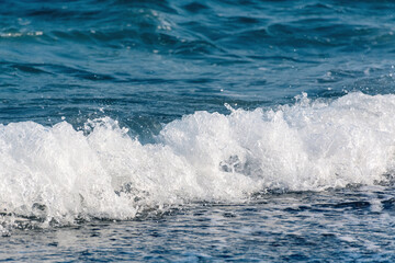 Beautiful sea wave with splashes of blue water and foam. Copy space business travel and leisure concept.