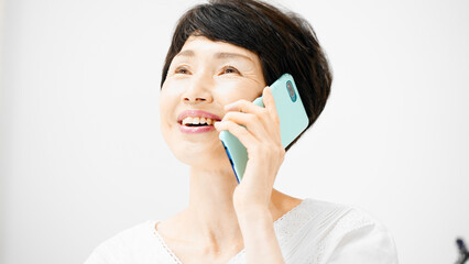 スマートフォンで通話をするミドル女性