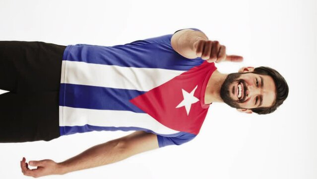 Full-length vertical shot of a happy young Latin American man in a t-shirt with Cuba's flag. High quality 4k footage