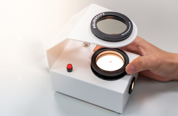 The Gemologist's expertise in her laboratory fix the value of precious stone of the polariscope.