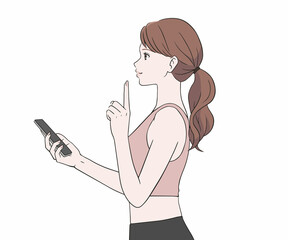 スマホを持ち指を差すスポーツインストラクター