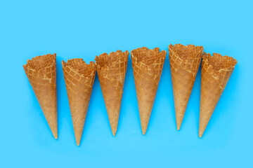 Empty ice cream cone on blue background.