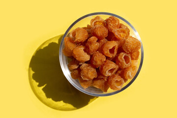 Dried longan on yellow background.