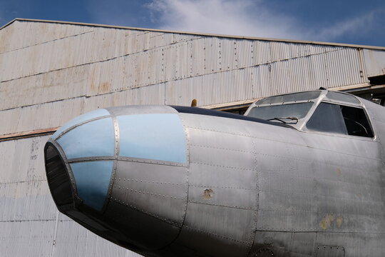 Vintage aircraft in front of hangar