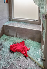 Shattered glass covers the shower floor after the door exploded, leaving the bathmat in a pile of...