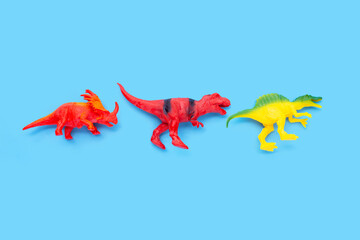 Plastic dinosaur toys on blue background.