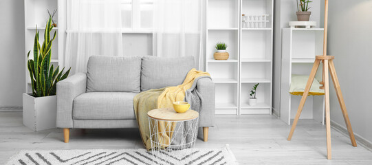 Interior of modern living room with comfortable grey sofa