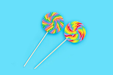 Rainbow lollipop on blue background.