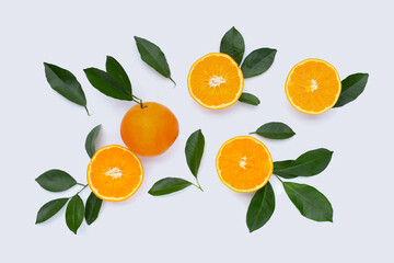 Orange fruit with green leaves on white background.