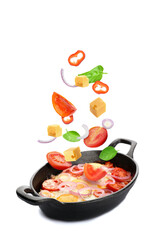 Baking dish with tasty Shakshouka and flying fresh ingredients on white background