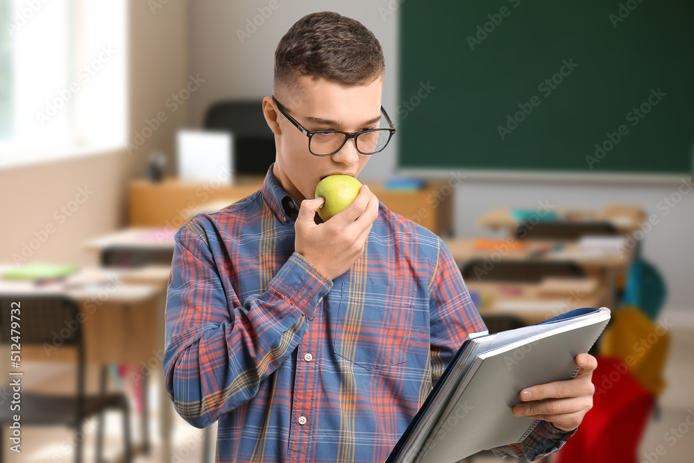 Canvas Prints male student eating apple in classroom