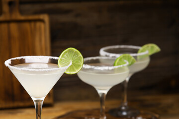 Glasses of tasty margarita cocktail on table, closeup
