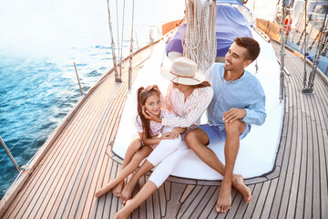 Happy young family resting on yacht