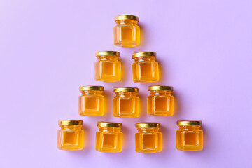 Jars with honey on purple background