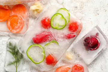 Fresh cut vegetables frozen in ice on light background
