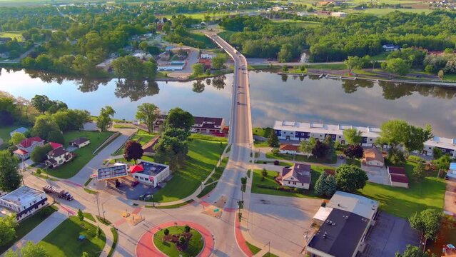 Rush hour in small town America, roundabout with bridge across river, aerial view.
