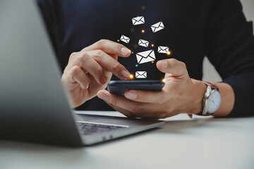 Naklejka premium Hand of businessman using smartphone with e-mail icon.