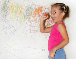 Little girl doodling painting and drawing on the wall