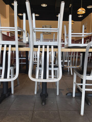 steel chairs upside down on table business closing background image - obrazy, fototapety, plakaty