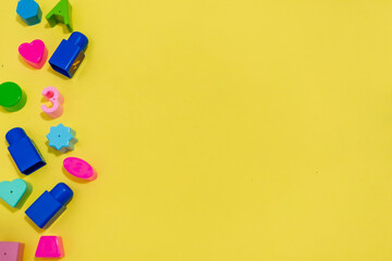 Plastic children's toys frame on yellow background