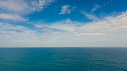 Aerial view of Blue sea with waves and sky with clouds. Ocean skyline.