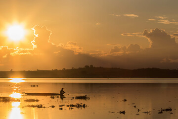 Fisherman in boat at the lake on sunset time