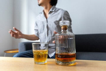 Man enjoy a glass of whiskey sitting at sofa at home.