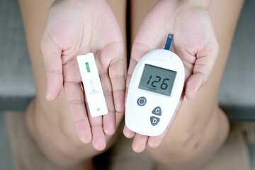 Hand-checking diabetes and high blood sugar with digital blood pressure monitor and covid-19 test...