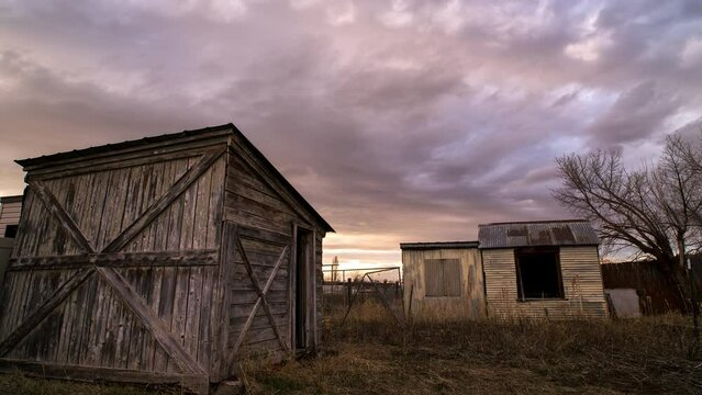 Timelapse of old rustic sheds during sunset in Wyoming viewing old coop.