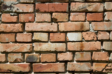 The wall is made of old red brick.