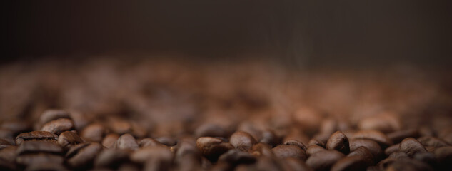 The hot of brown roasted coffee beans on brown background long banner with copyspace, Healthy...