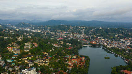 The city of Kandy is located among the mountain peaks with a tropical forest.