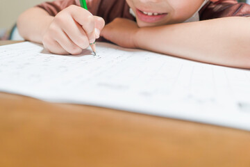 宿題のプリントを書く小学一年生の男の子。国語、ひらがなの勉強