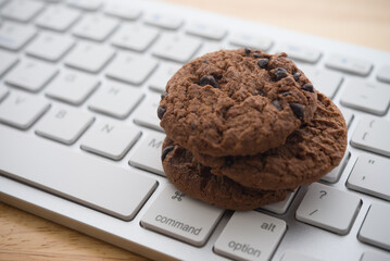 Chocolate chip cookies on keyboard computer background copy space. Cookies website internet...