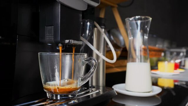 The fresh coffee maker is pouring coffee water onto clear glass. Drinks in restaurants are popular to drink in general. cup for Americano coffee with crema foam.
