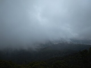 Mountain engulf with dark fog-like clouds
