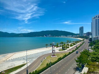 View of Quy Nhon city with a beautiful beach, long coastal route, clear blue sky, and high-rise hotels. Vietnam. Beautiful scenery in Vietnam