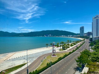 View of Quy Nhon city with a beautiful beach, long coastal route, clear blue sky, and high-rise hotels. Vietnam. Beautiful scenery in Vietnam