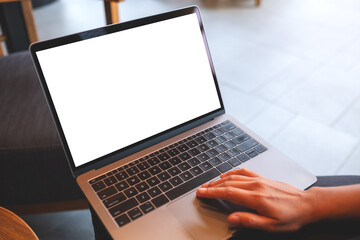 Mockup image of a woman working and touching on laptop touchpad with blank white desktop screen