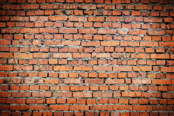 Fototapeta premium Wall of red brick with cement with vignette. Rough surface texture. Texture of an old brick wall