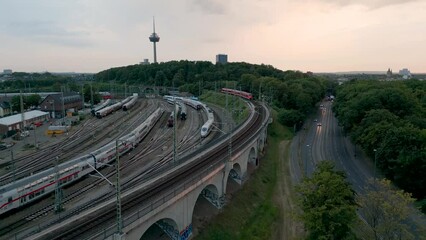 Train depot and railway yard aerial view of Cologne in Germany on a sunny evening with the tv tower in the background and a lot of trains in the yard sidings.