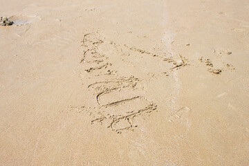 The beautiful sandy beach has the scribbles of tourists.