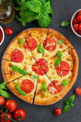 Fresh traditional Italian pizza Margarita or margharita with tomato sauce, mozzarella cheese and fresh green basil on top on a gray background. Top view, copy space.