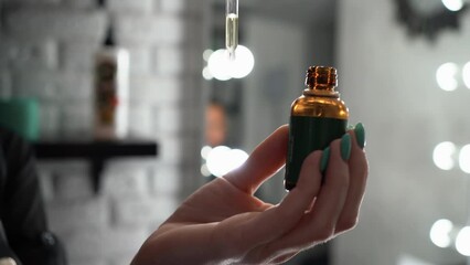 Oil for spa grooming and beard growth for man in a dropper in hands. Concept barbershop.