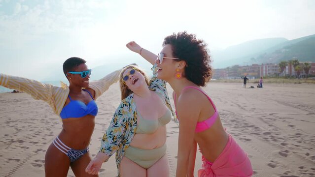 Beautiful multiethnic young women having fun on the beach during the summetime vacation. Storytelling representation of body positivity, self acceptance and individuality female concepts