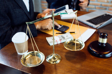 Justice and law concept.Male judge in a courtroom with the gavel, working with, computer and docking keyboard, eyeglasses, on table in morning light